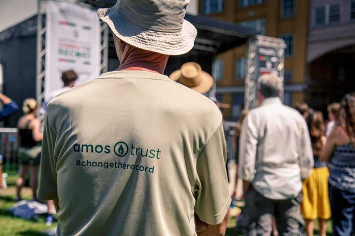 A man standing wearing his Amos Trust 'Change The Record' t-shirt