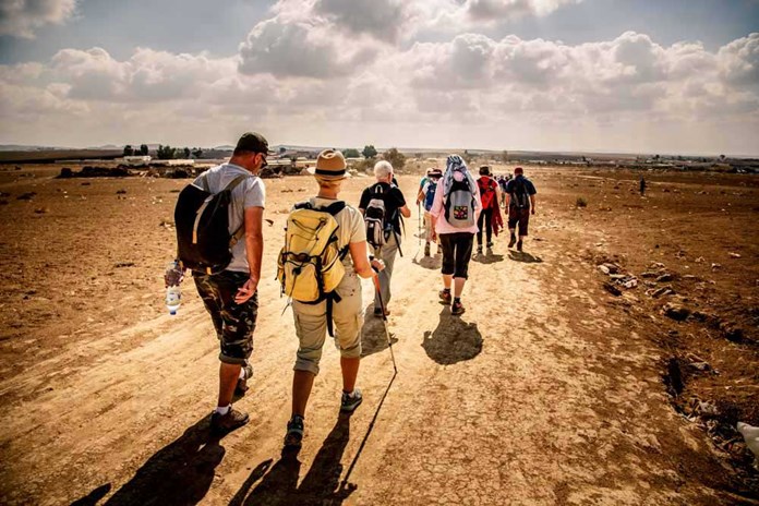 A group of people walking across the Negev desert in Israel.