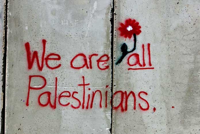 Graffiti on the Israeli Separation Wall reads, "We Are All Palestinians"