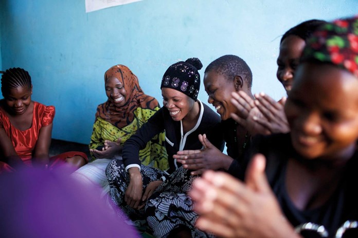 Women from Tanzania laughing together.
