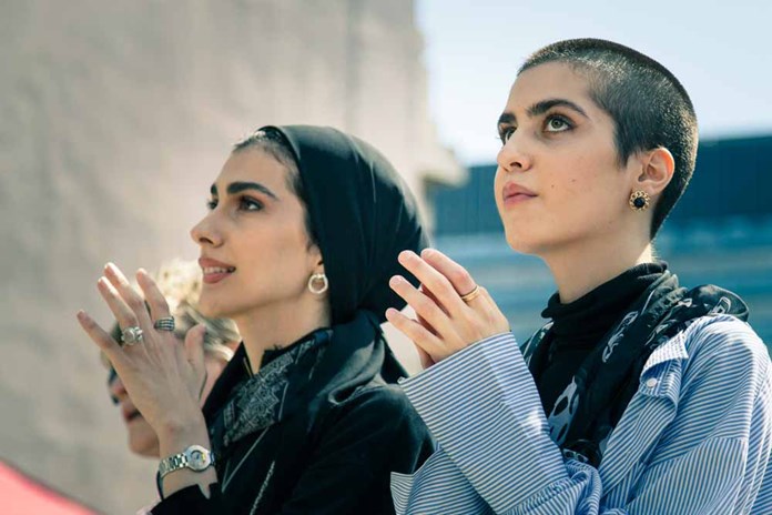Two Palestinian women clapping.