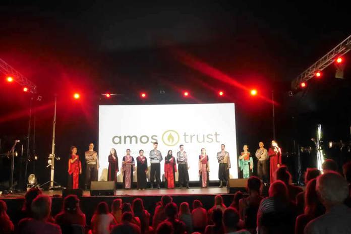 Young Palestinian dancers performing in front of a large crowd at a festival.