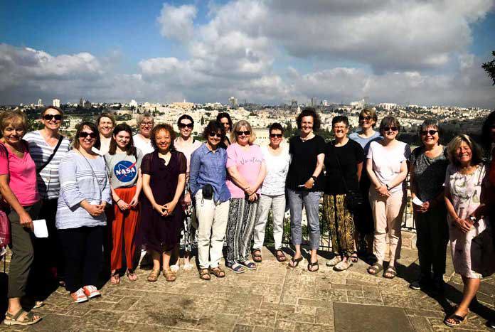 A group of women standing at the top of the Mount of Olives over-looking the Old City of Jerusalem.