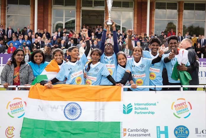 Team celebrating behind the flag of India after winning the Street Child Cricket World Cup at Lord's.