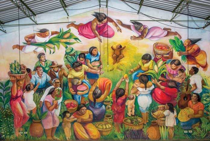 A mural depicting campesino life as a nativity scene including political and cultural figures from Latin America.