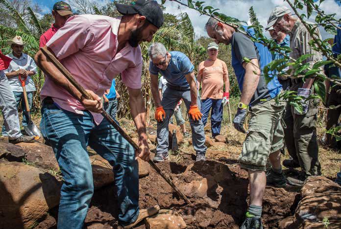 DIGGING — Amos supporters help a community in La Joya to dig a micro-dam to store water running from the roof.