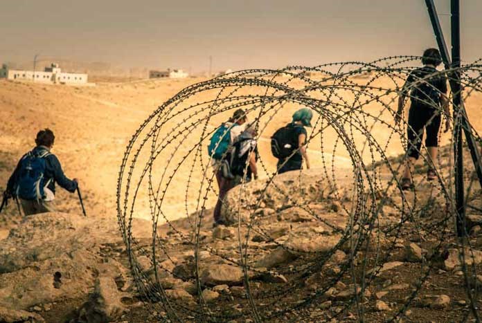 Amos Trust supporters walking by some barbed wire – West Bank, 2017