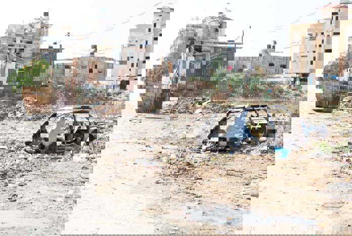 A bombed-out car in rubble – Gaza City.
