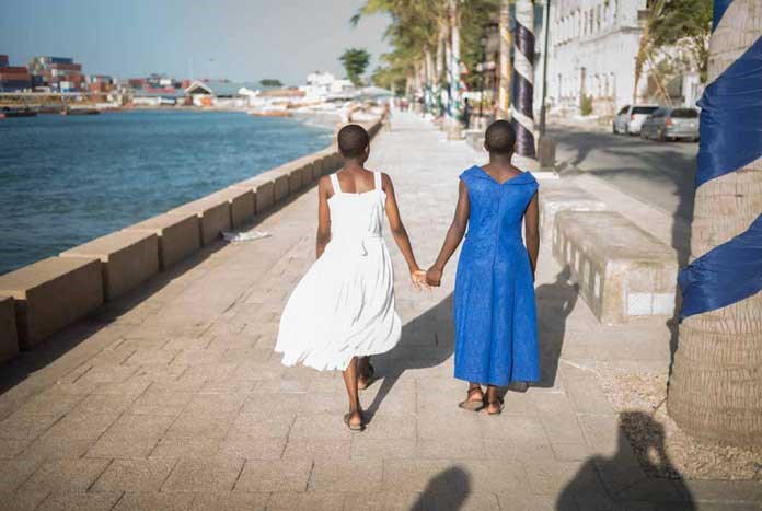 Two young girls walking hand-in-hand in Tanzania