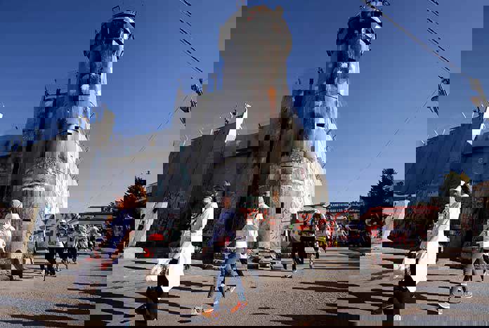 Participants in the Palestine Marathon in Bethlehem run by the 8 metre-high Separation Wall and one of its watch towers.