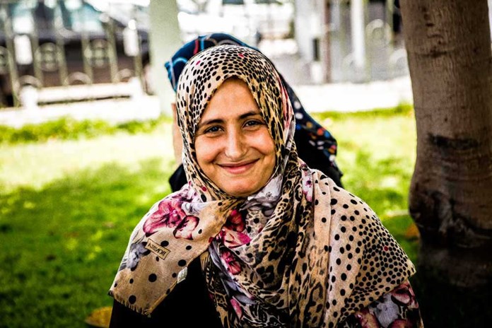 A women sits and smiles in the garden of Al Ahli Arab Hospital in Gaza.