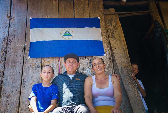 A Nicaraguan family sit outside their house in Nancital, Teustepe.