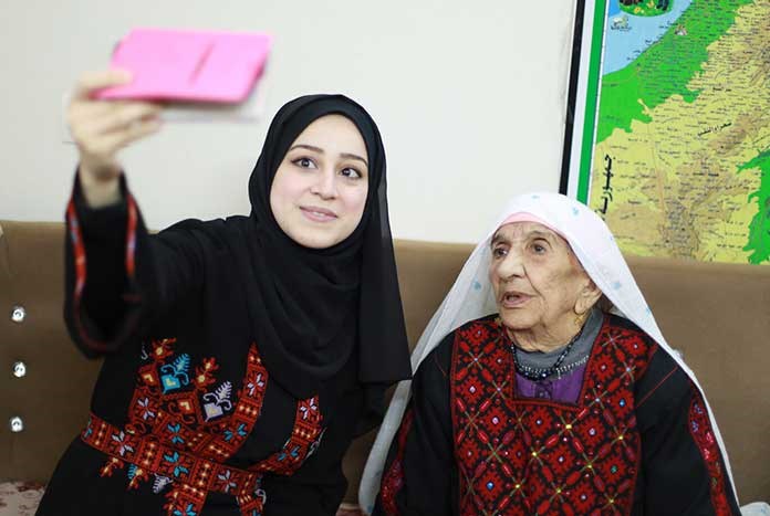 A young Gazan woman takes a Selfie with an old Gazan woman.