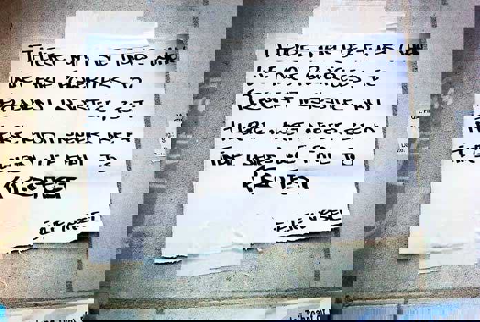 A piece of paper stuck the the pavement on a demo reads, "There may be times when we are powerless to prevent injustice, but there must never be a time when we fail to protest."