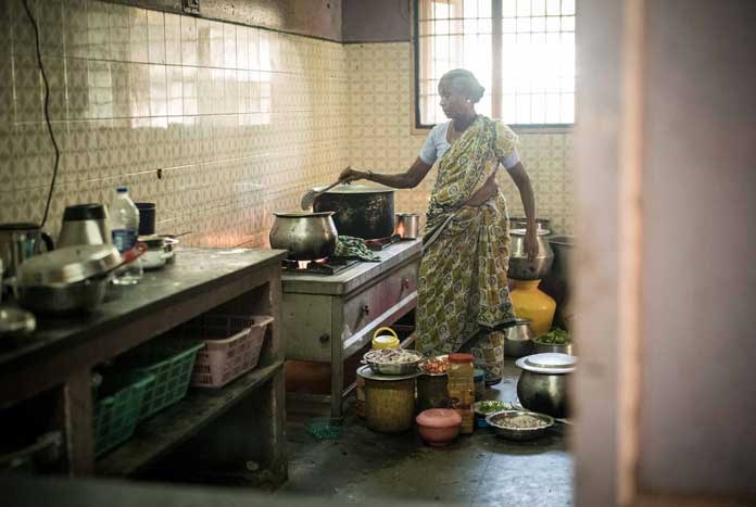 A women cooks in the kitchen at Karunalaya in Chennai, India