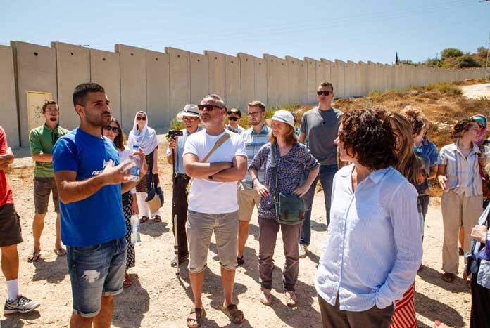 A group from the UK listening to a Palestinian tour guide in the West Bank