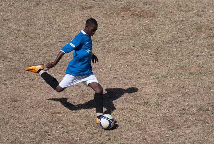 A female footballer about to kick the ball.