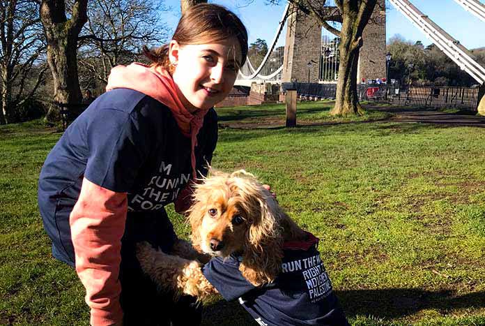 A young girl and her dog getting ready to join a fundraising run.