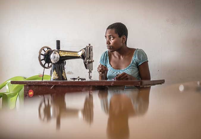 A young Tanzanian woman working at an old sewing machine in Mwanza, Tanzania.