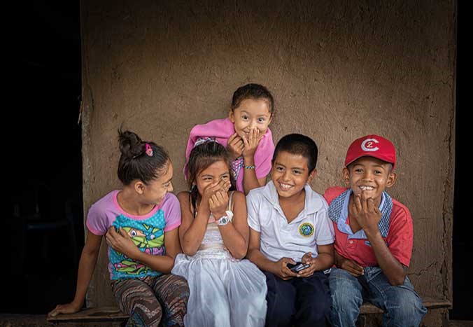A group of young Nicaraguan children smiling and laughing together in rural Nicaragua.
