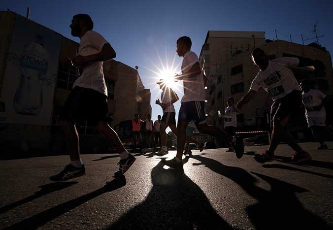 A small group of runners at dusk running the Palestine Marathon in Bethlehem.