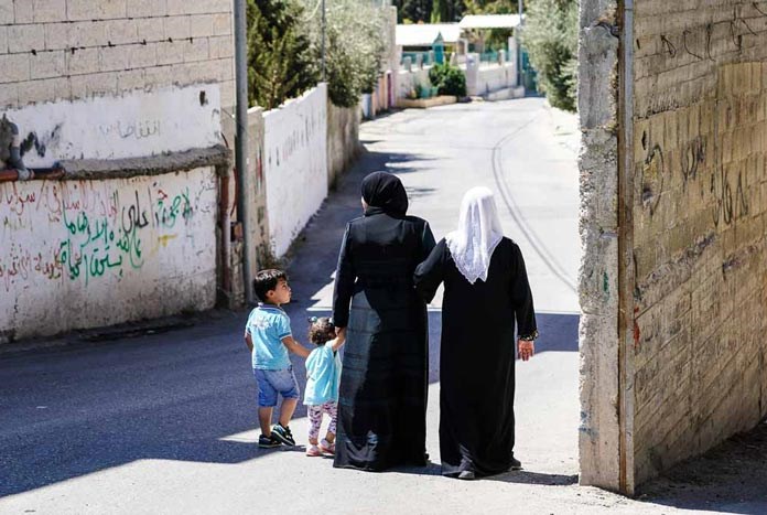 A family walking through a refugee camp in Bethlehem, Palestine