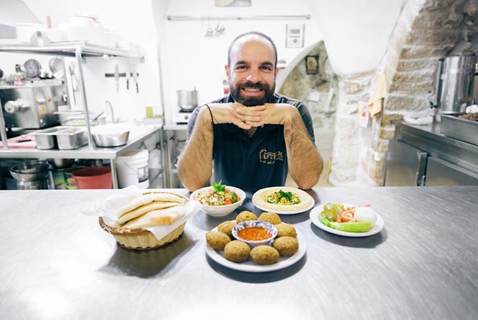 A Palestinian chef presents a meal of hummus, falafel and bread.