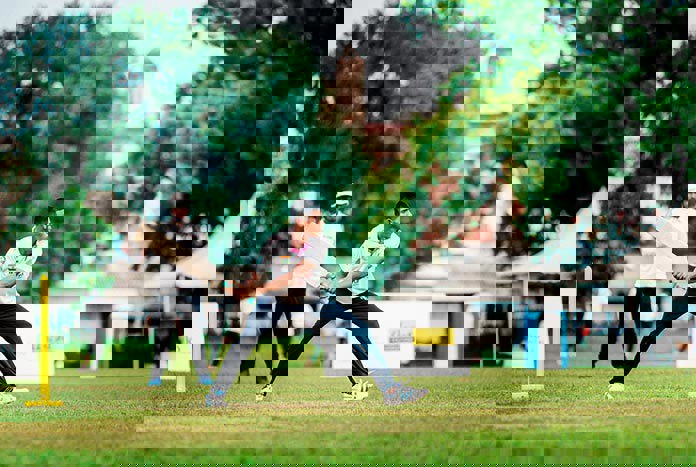 A young Indian man hits a six in a cricket match at the 2023 Street Child Cricket World Cup in Chennai, India.