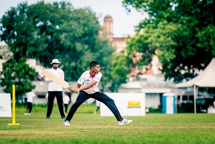A young Indian man hits a six in a cricket match at the 2023 Street Child Cricket World Cup in Chennai, India.