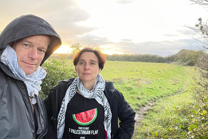 A man and a woman standing in a field.