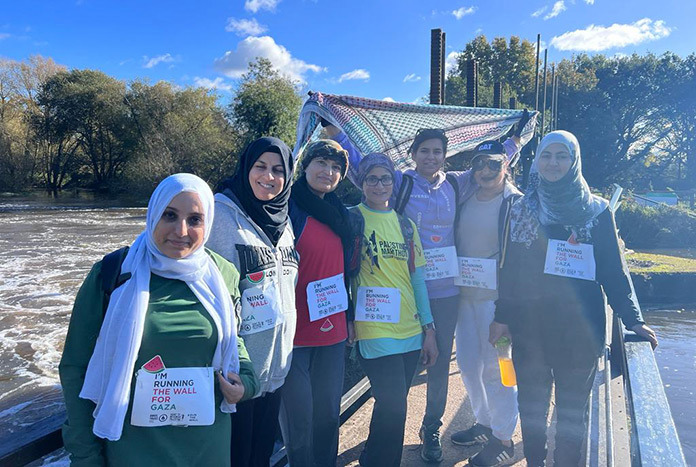 A group of Palestinian women wearing signs that read, "We are running the Wall for Gaza."