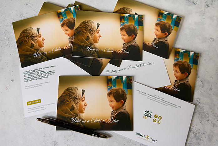Christmas cards featuring a mother and her child from Gaza laying on a marble worktop.