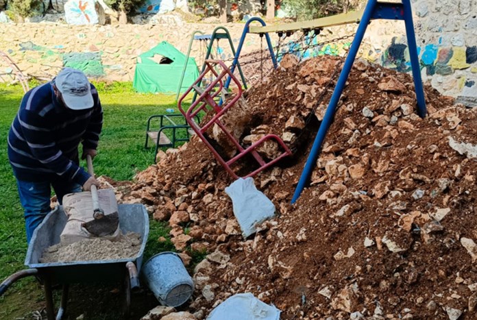 Palestinian workmen moving earth in the Wi'am garden ready for the new structure to be built.