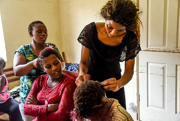 Young women in Durban, South Africa, styling each others hair.