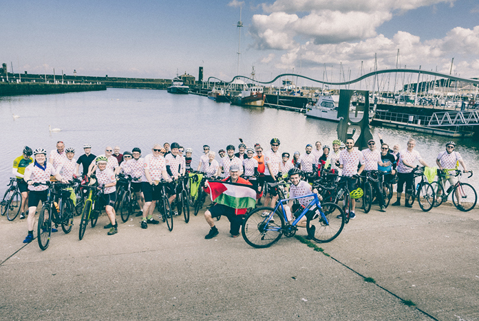Amos Road Club members dipping their back wheels in the sea in Whitehaven in the UK.