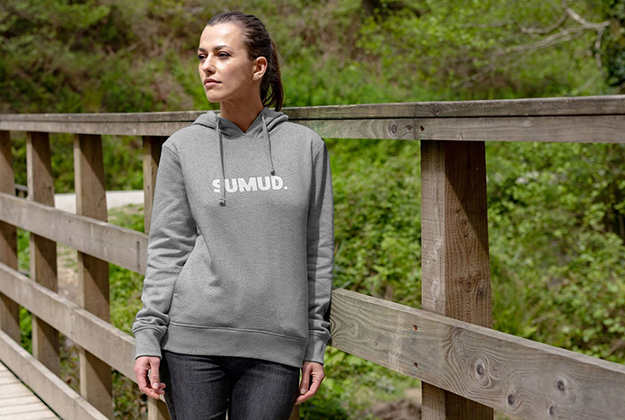 A young woman wears a grey fitted Sumud Hoodie from Amos Trust