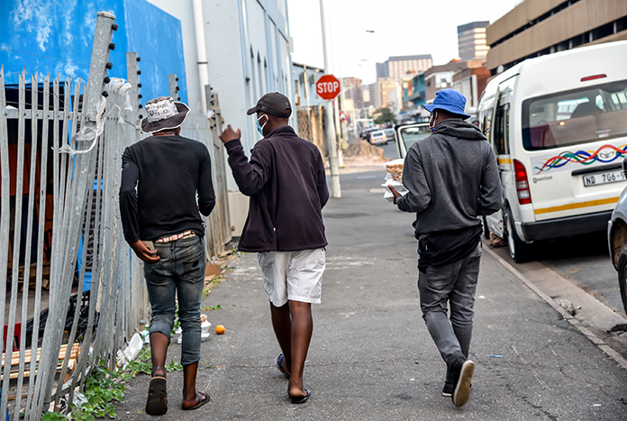 Three young men walking along a street in Durban, South Africa.