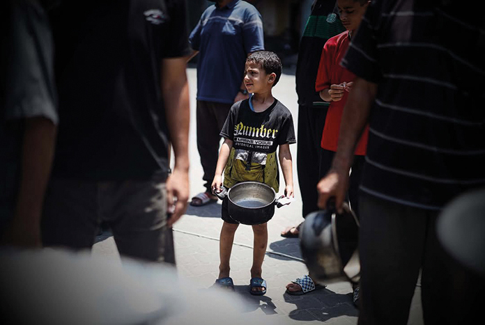 A young boy searches for food in Gaza — May 2025